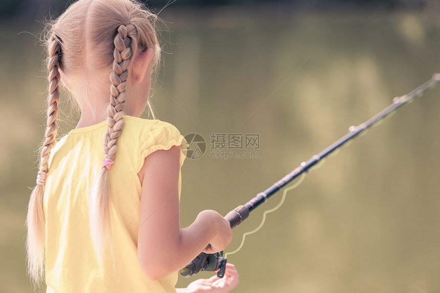 坐银行钓鱼的可爱女孩的肖像图片