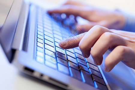背光键盘点击个男人键盘上的手,蓝色背光设计图片