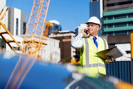 建筑工地的工程师建设者工程师建筑工人施工场景穿着安全背心记事本图片