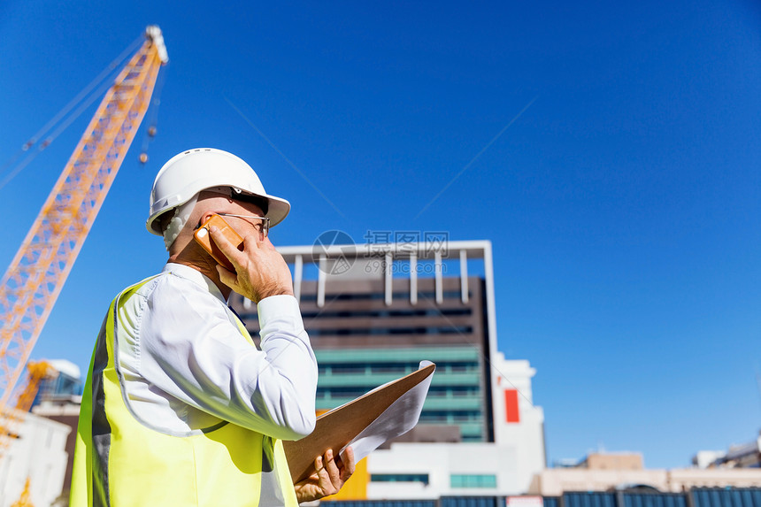 建筑工地的工程师建设者工程师建筑工人施工场景穿着安全背心记事本图片