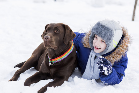 学龄儿童与狗冬季公园最好的朋友高清图片