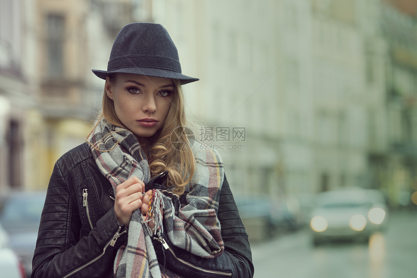 城市时尚美女肖像,戴着围巾帽子,城市街道上,她脸上雀斑,表情甜美图片