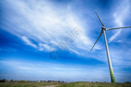 蓝天下田野里的风力涡轮机高清图片