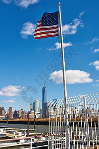 美国蓝天上迎风飘扬,背景纽约市曼哈顿的天际线高清图片
