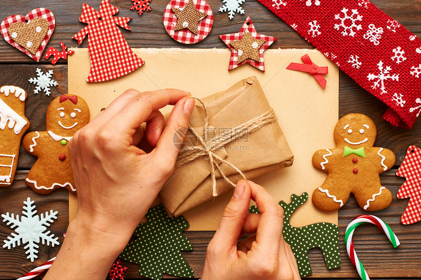 女手诞礼物自制姜饼饼干,手工装饰木制背景上图片