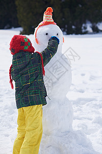 小男孩堆雪人图片
