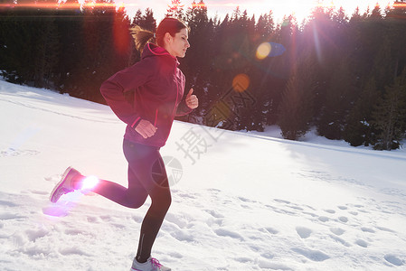 你的女人森林里的雪地上户外慢跑,健康的冬季生活方式娱乐活动图片