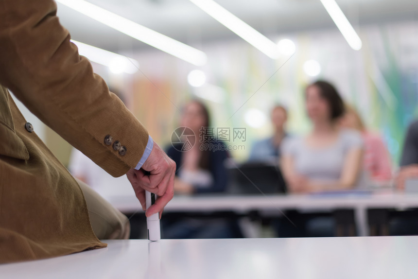 学校课堂上给学生讲授课程时,用记号笔教师的手图片