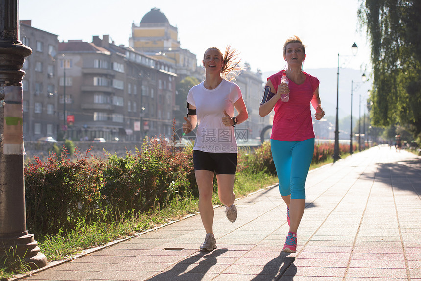 两位中女朋友慢跑晨练,背景为日出图片
