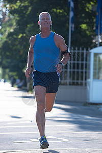 老年男子在城市街道慢跑晨练图片