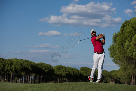 高尔夫球手击球与司机球场上美丽的晴天背景图片