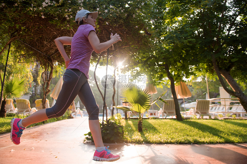 运动的女人大早人行道上慢跑图片
