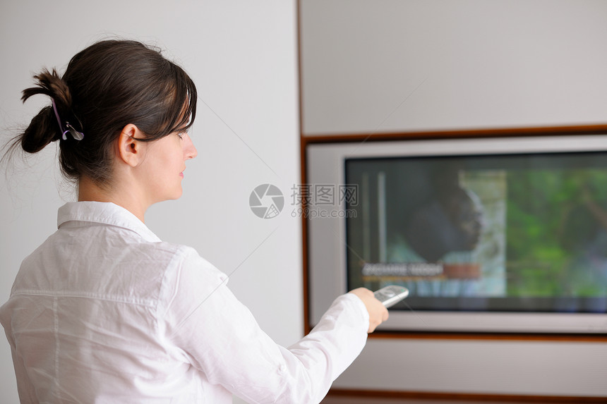 快乐的轻女人现代家庭客厅看电视图片