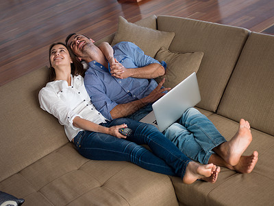 快乐的轻轻松的夫妇现代家庭室内工作笔记本电脑背景图片