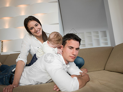 幸福的轻家庭夫妇与美丽的新生婴儿现代家庭乐趣图片