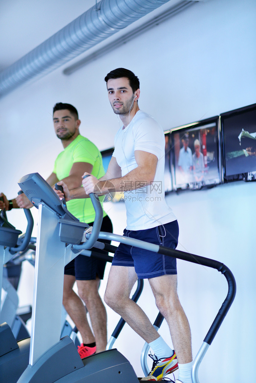 群轻人现代体育健身房的跑步机上跑步图片