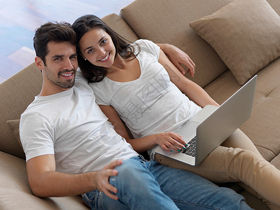 快乐的轻轻松的夫妇现代家庭室内工作笔记本电脑背景图片