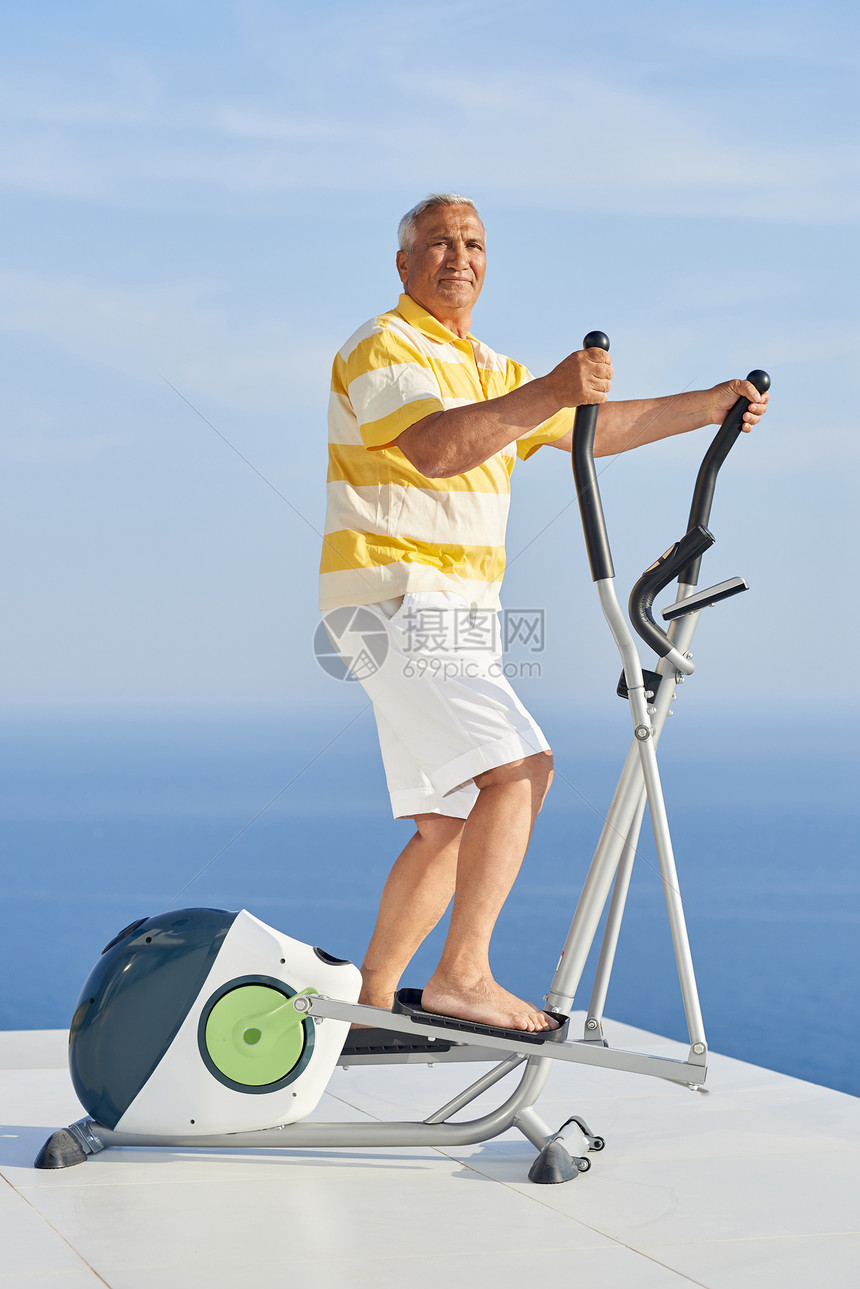健康的老人现代家庭跑步机上锻炼,带海景图片