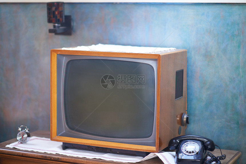 复古风格的客厅细节木制旧桌子上的电视电话时钟图片