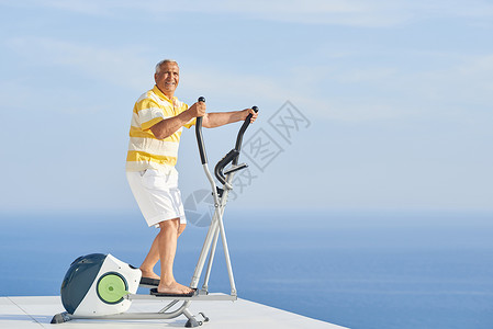 健康的老人现代家庭跑步机上锻炼,带海景图片