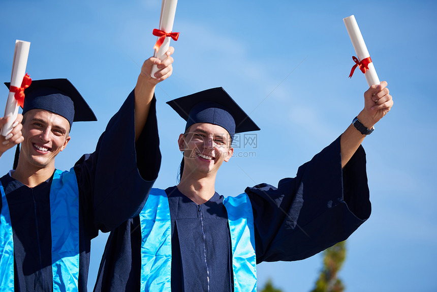 毕业日,轻的毕业生们站大学大楼前图片