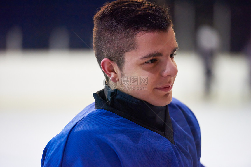 轻冰球运动员黑色背景下训练的肖像图片