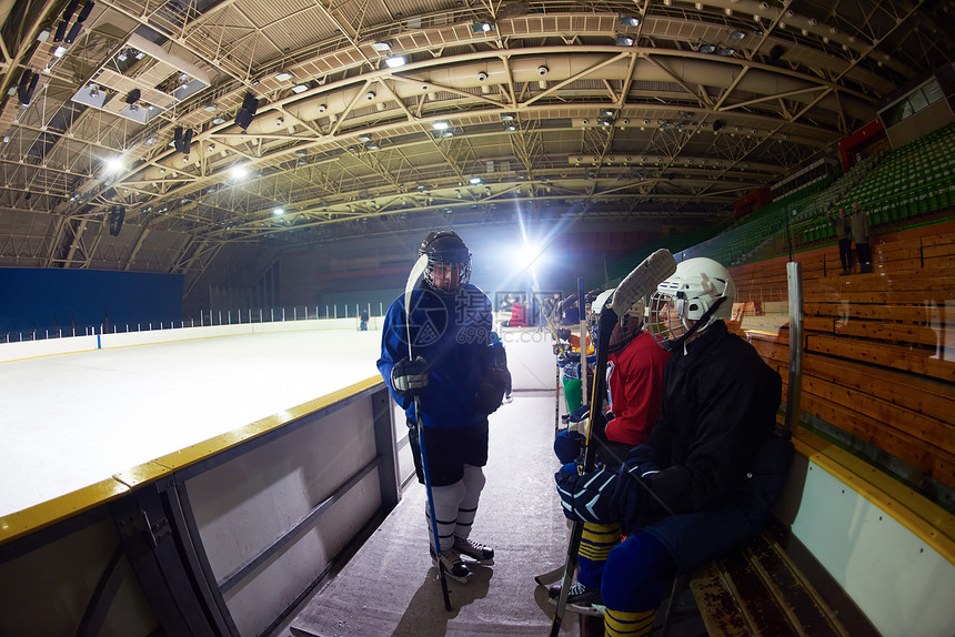 冰球运动员,群队友长凳上等待开始比赛图片