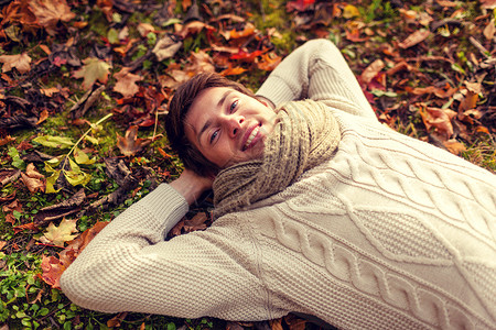 季节,幸福人的靠近微笑的轻人躺地上草地秋天公园的落叶图片
