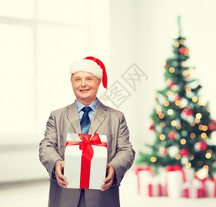 商业,圣诞节,幸福的微笑的老人穿着西装诞老人的帽子带礼物图片