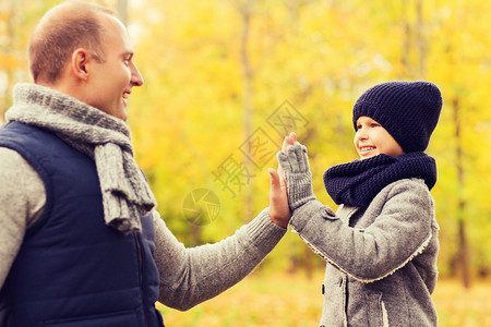 家庭,童,季节,手势人的快乐的父子秋天的公园里击掌图片