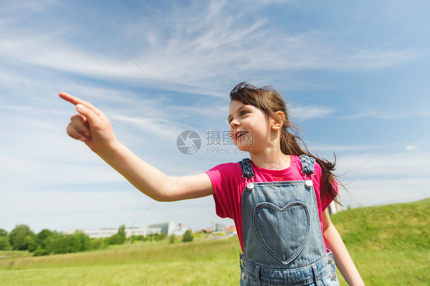 夏天,童,休闲,方向人的快乐的小女孩指着绿色的夏天田野图片