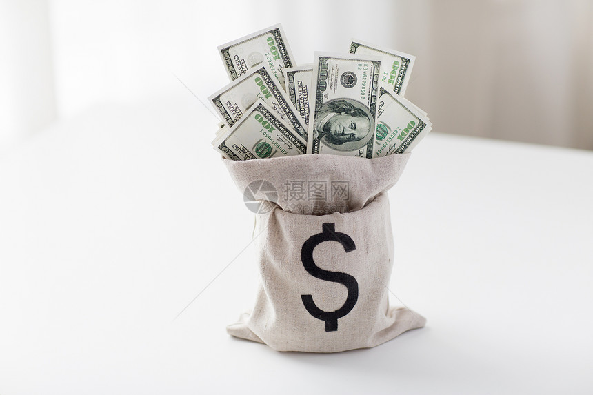 商业金融投资储蓄现金把美元纸币放银行桌子上的袋子里图片