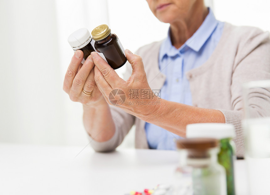龄,医学,保健人的近距离的老妇女看着罐子与药物家里医院办公室图片