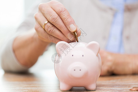 金融的进入之内储蓄金钱金保险退休人的把硬币放进储蓄罐背景