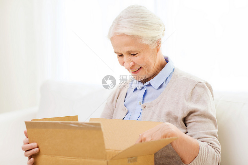 龄,送货,邮件,航运人的快乐的微笑老年女子家里看打开的包裹箱图片