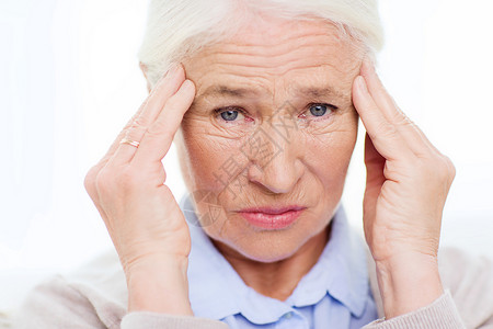 保健疼痛压力龄人的患头痛的老妇女的脸图片