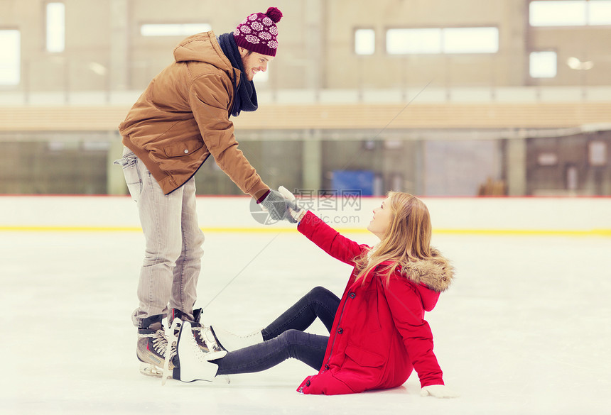 人,友谊,运动休闲的微笑的男人帮助女人溜冰场上升图片
