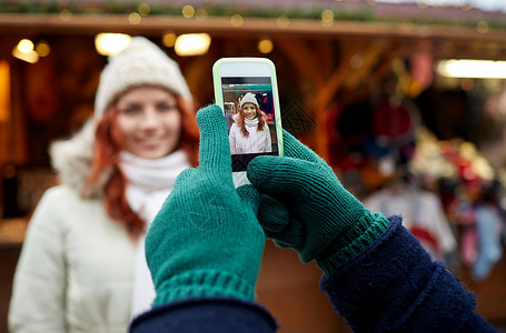 假日,冬天,诞节,技术人的快乐的游客穿着温暖的衣服,用智能手机老城拍照图片