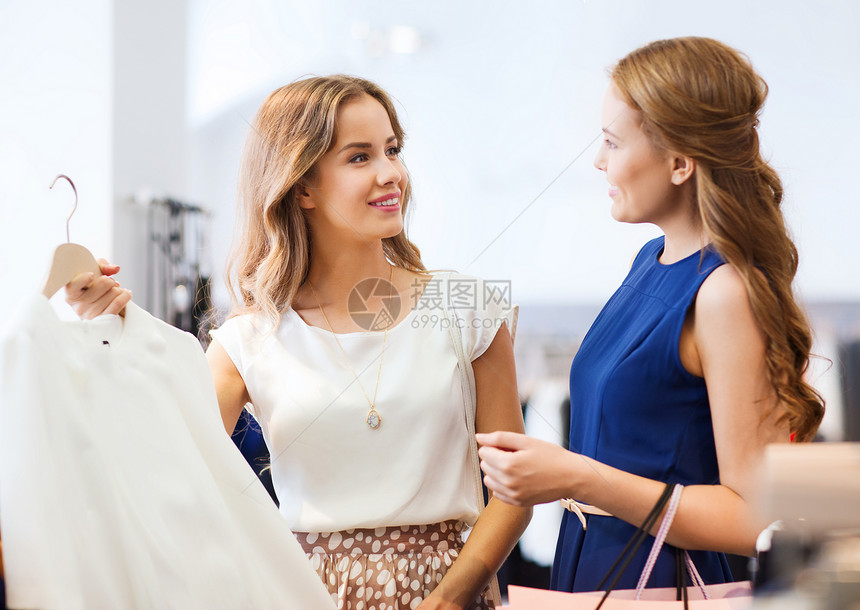 销售,消费主义人的快乐的轻妇女与购物袋选择衣服服装店图片