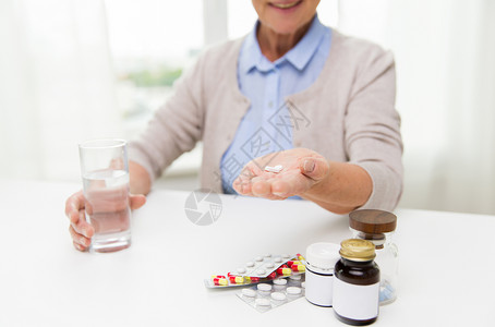 龄,医学,保健人的亲密的快乐老妇女与药丸璃水家里图片