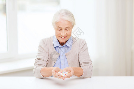 龄,医学,保健人的快乐的老妇女家里医院办公室吃药图片