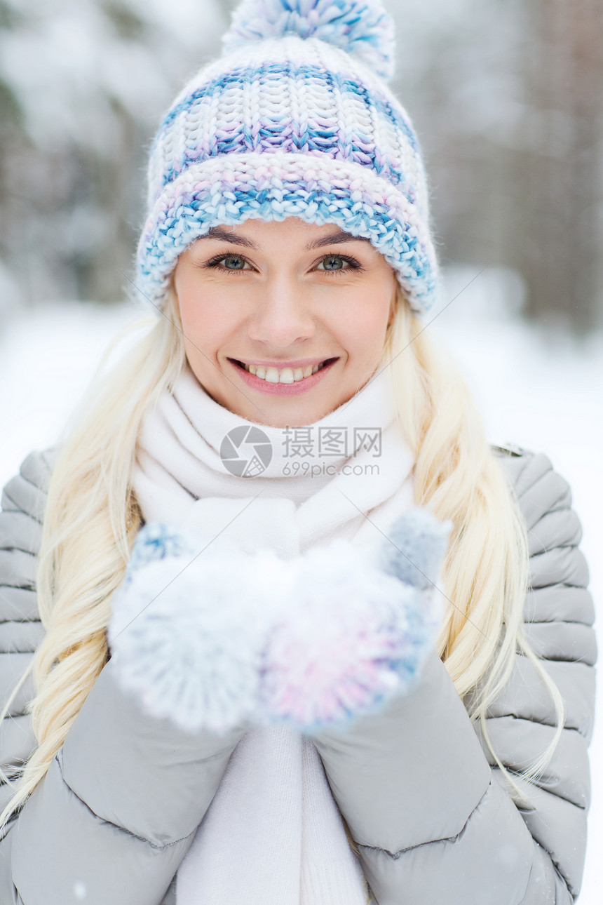 季节,诞节人们的快乐的微笑轻女人冬天的森林里捧着雪图片