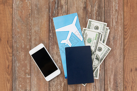 旅游,旅游物品机票,金钱,智能手机护照木桌背景图片