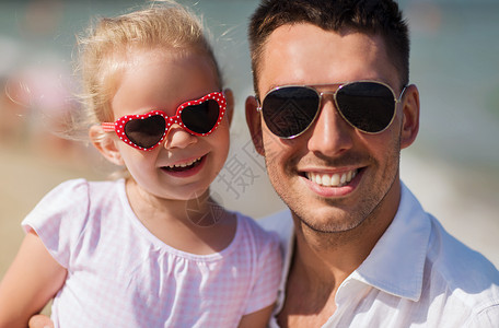 家庭,旅行,假期,收养人们的快乐的父亲小女孩戴着太阳镜夏天的海滩图片