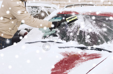 运输,冬天,人车辆的特写的人清理雪汽车挡风璃用刷子背景图片
