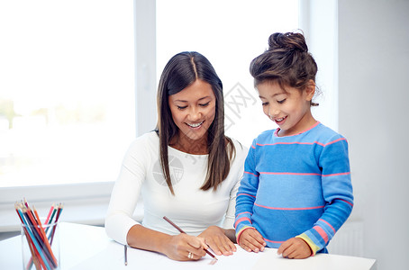 家庭,孩子,创造力快乐的人的快乐的母亲女儿家里幼儿园用铅笔画画图片