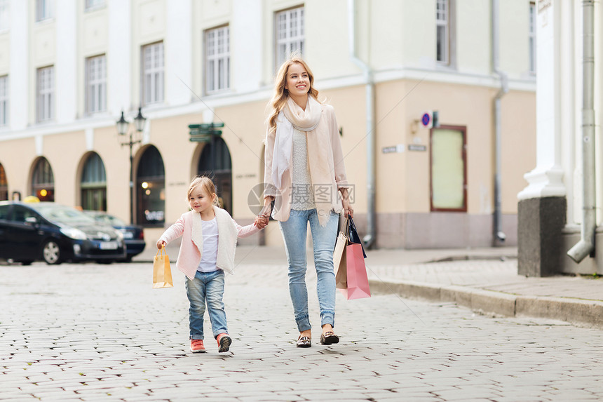 销售,消费主义人们的快乐的母亲孩子与购物袋走城市街道图片