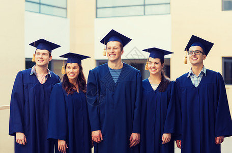教育,毕业人的群微笑的学生穿着沙黑板户外长袍图片