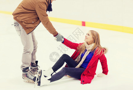 人,友谊,运动休闲的微笑的男人帮助女人溜冰场上升背景图片