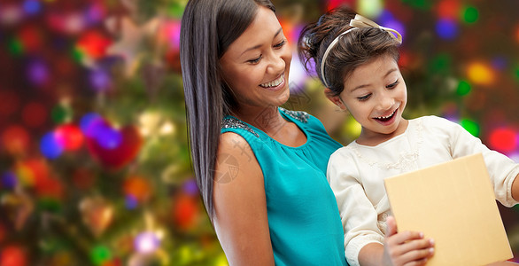 节日,生日,家庭,童人的快乐的母亲小女孩与礼物的灯光背景图片